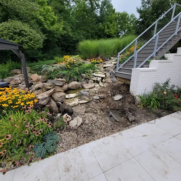 Landscape with stone waterfall in backyard in Fishers, IN