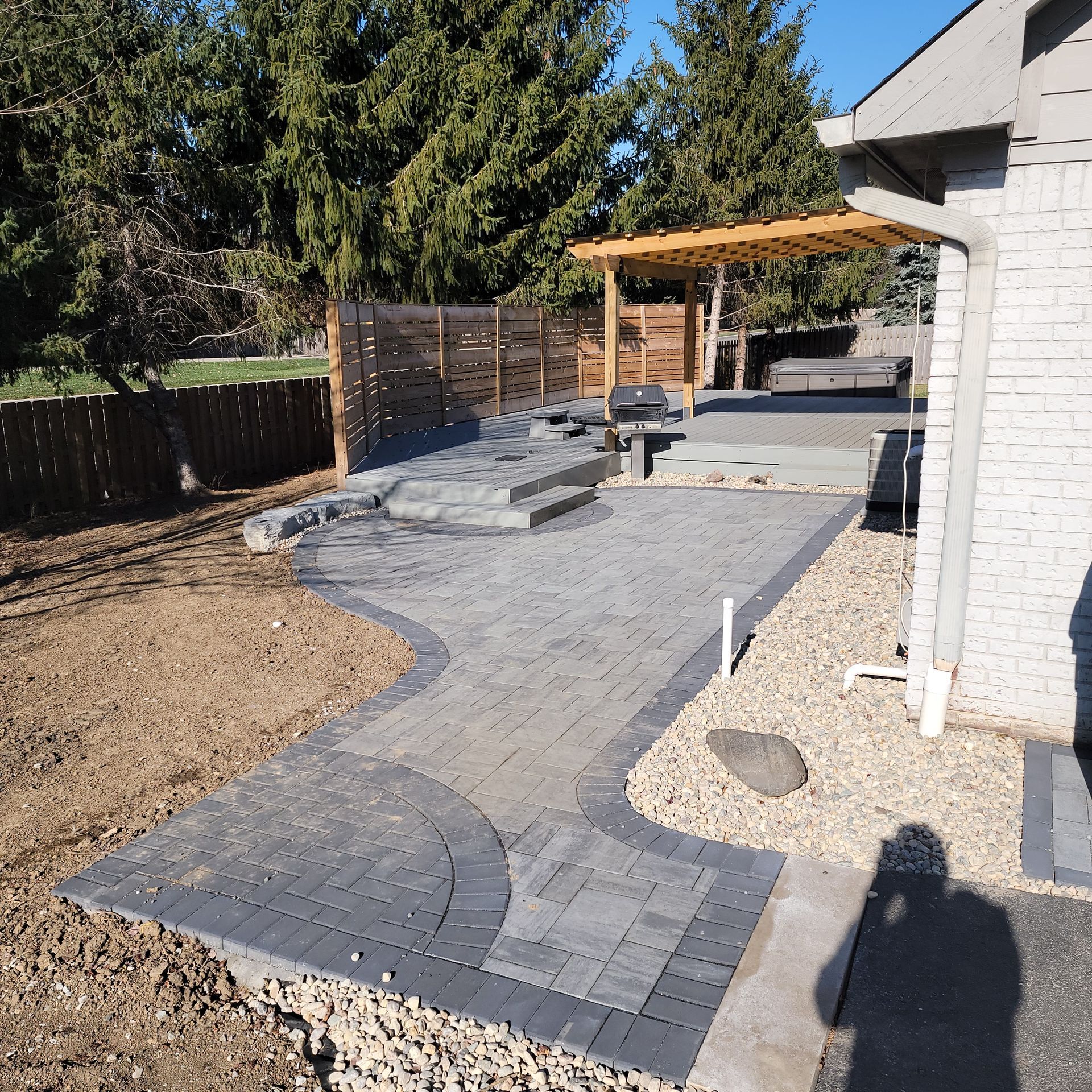 natural wood pergola on grey walk-out deck with privacy fence