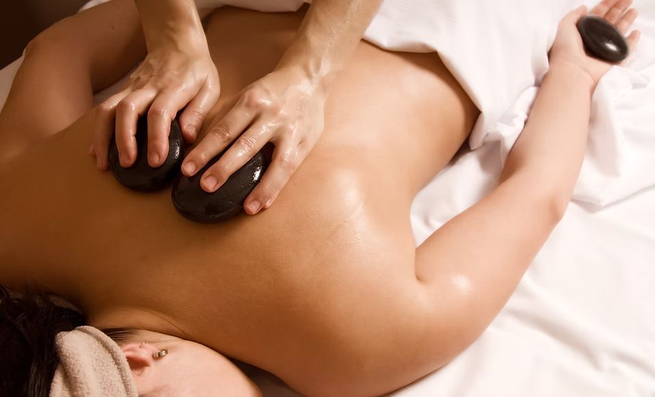 A woman is getting a hot stone massage at a spa.