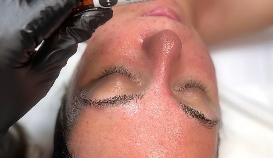 A woman is getting a facial treatment at a beauty salon.