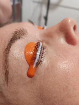 A close up of a woman 's face with orange paint on it.