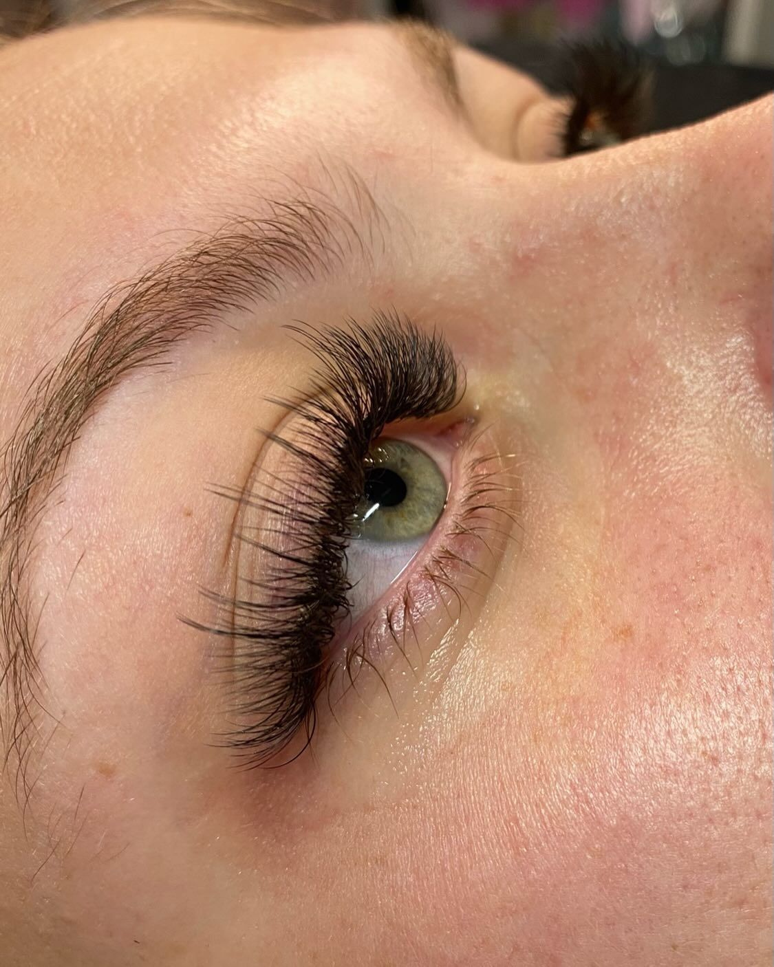 A close up of a woman 's eye with long eyelashes.