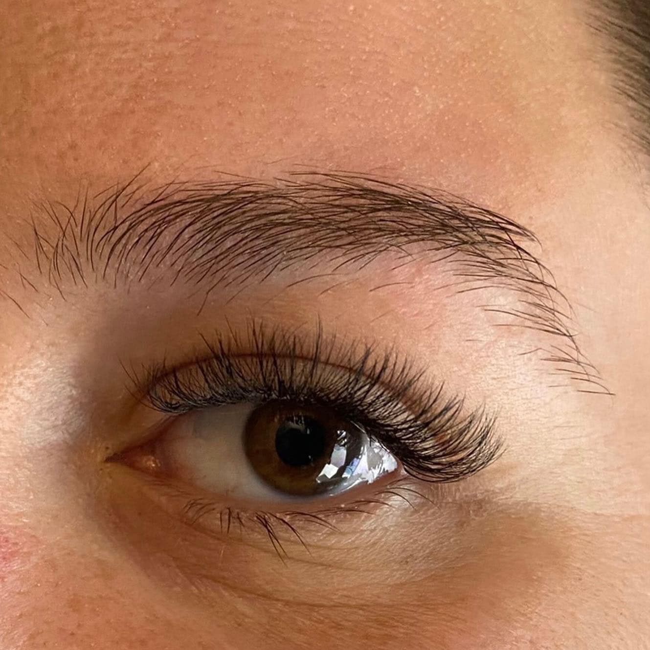 A close up of a woman 's eye with long eyelashes.
