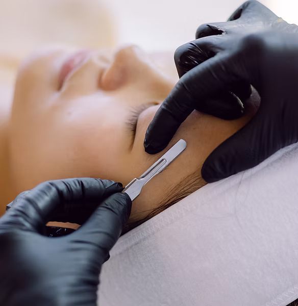 A woman is getting a facial treatment with a scalpel