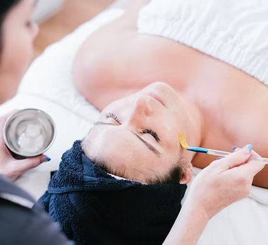 A woman is getting a facial treatment at a spa.