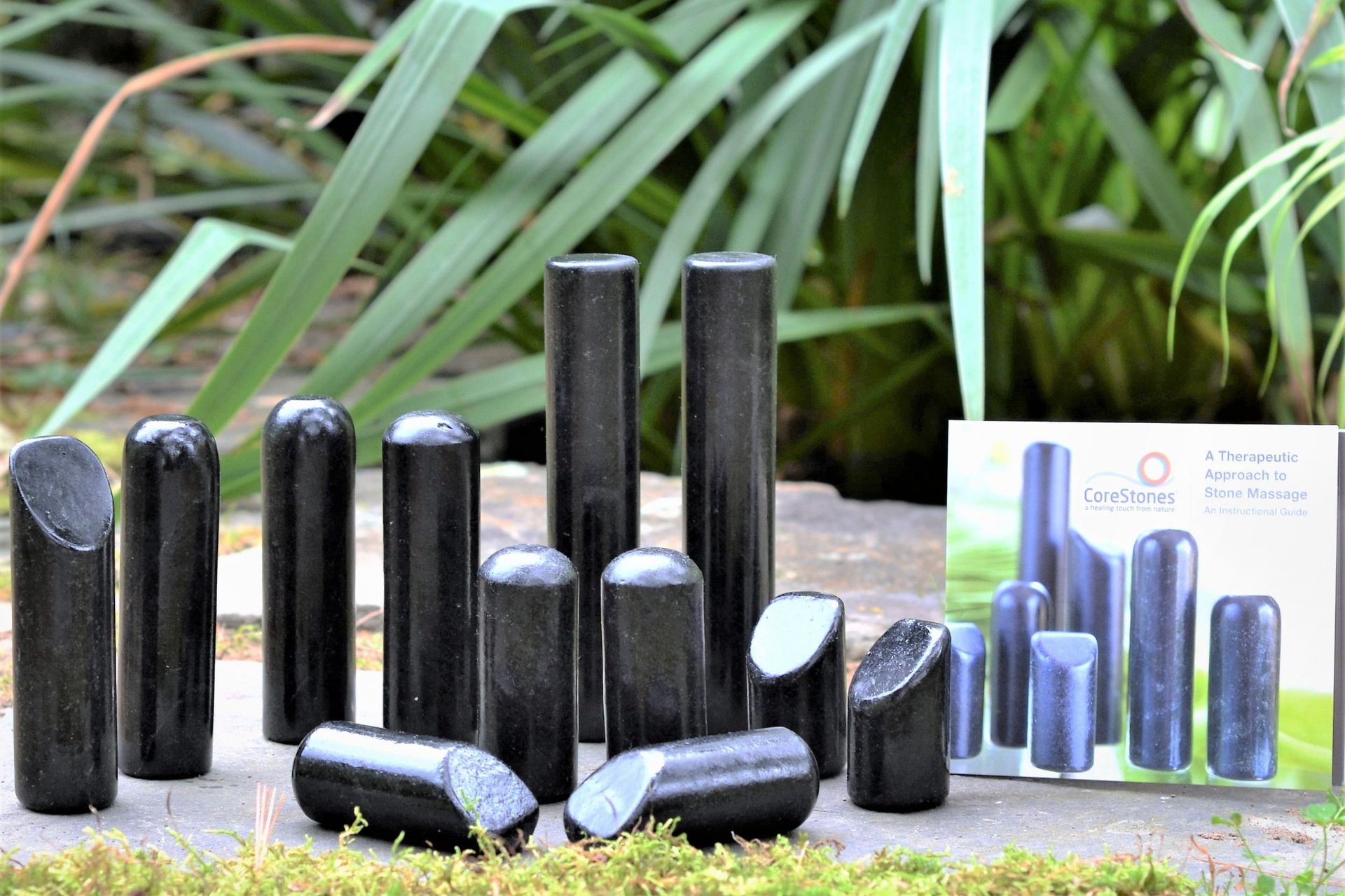 A bunch of black sticks are sitting on a rock next to a box.