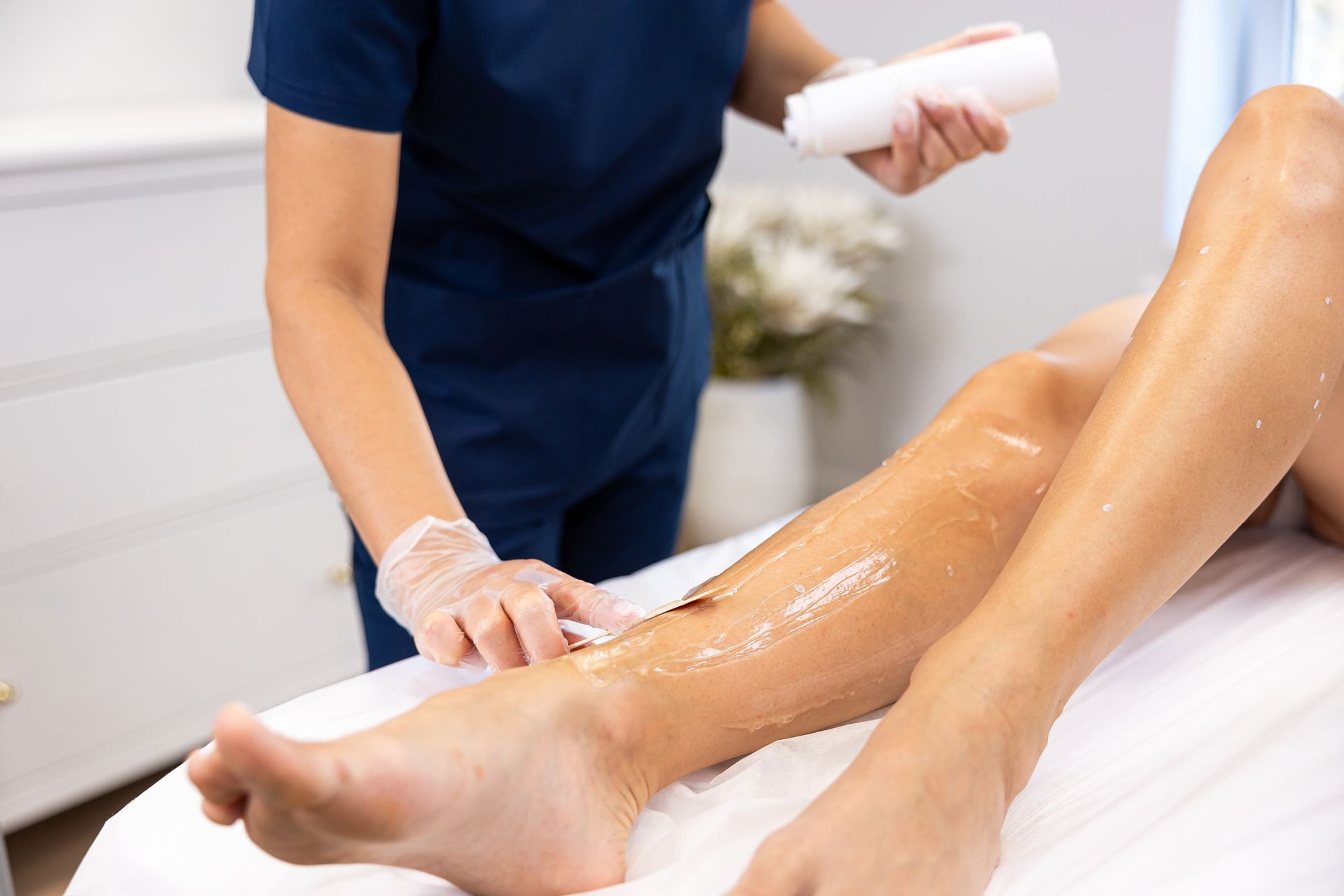 A woman is getting her legs waxed at a beauty salon.