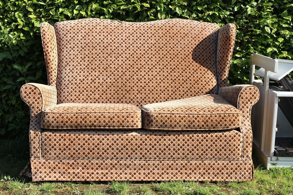 An old two-seater brown patterned wingback sofa sits out on the lawn — Smiley Rubbish Removal In Wauchope, NSW