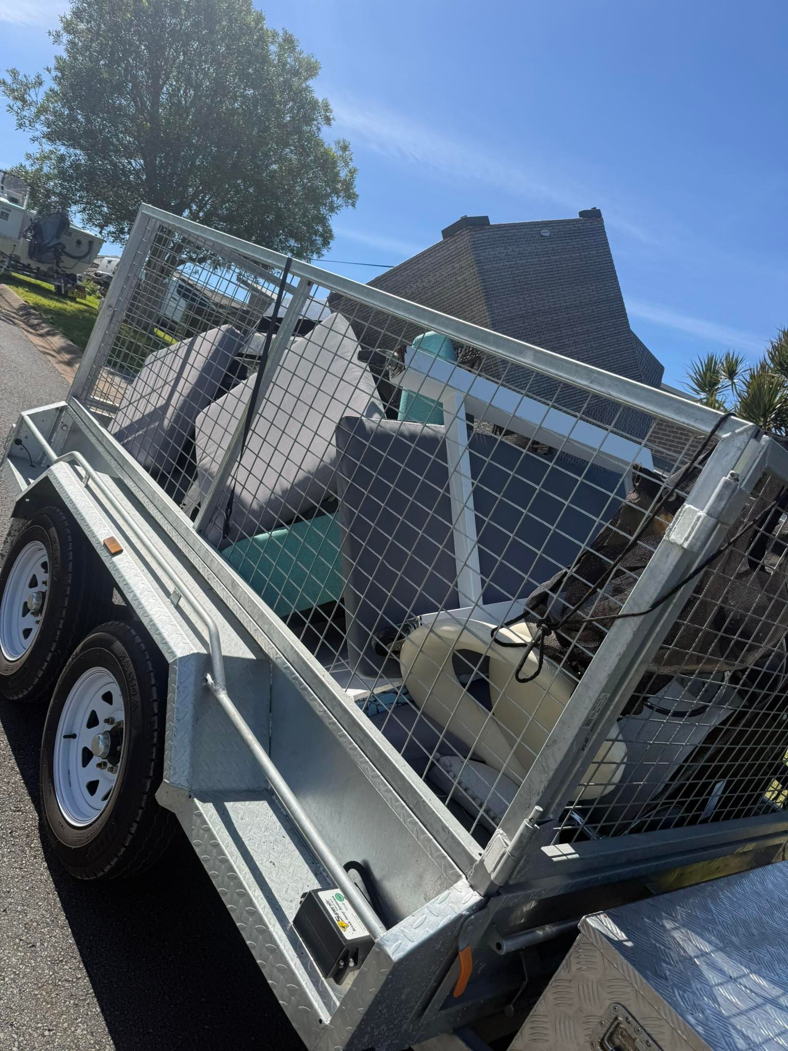 A Utility Trailer Parked Outdoors, Filled With Household Junk, Chairs — Smiley Rubbish Removal In Wauchope, NSW