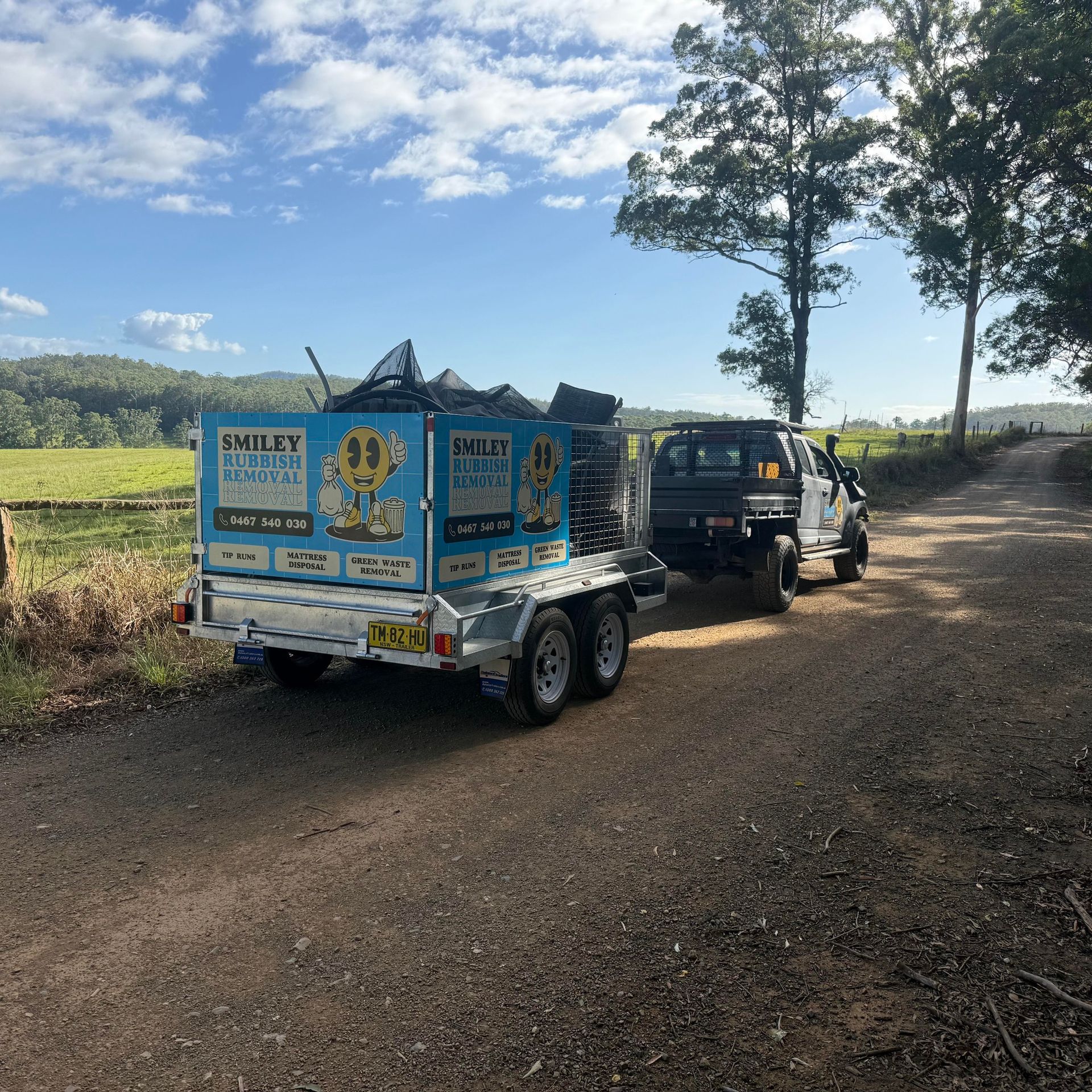 A Smiley Rubbish Removal Trailer Towed by a Black Pickup Truck — Smiley Rubbish Removal In Wauchope, NSW
