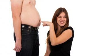 Eine Frau zeigt auf den Bauch eines Mannes