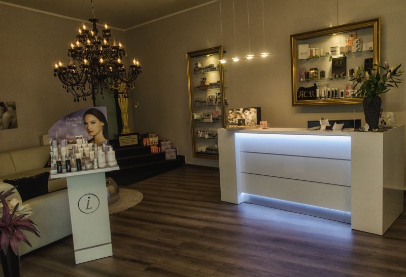 Ein Empfangstresen in einem Salon mit einem Kronleuchter, der von der Decke hängt.