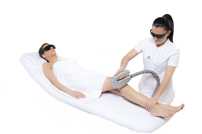 Eine Frau lässt sich an den Beinen eine Laser-Haarentfernung durchführen.