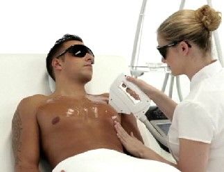 Ein Mann lässt sich die Haare auf der Brust mit einem Laser entfernen.