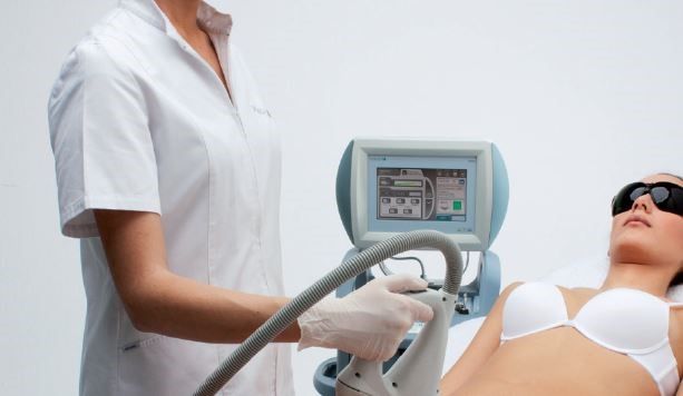 Eine Frau in einem weißen BH lässt sich die Haare mit einem Laser entfernen.