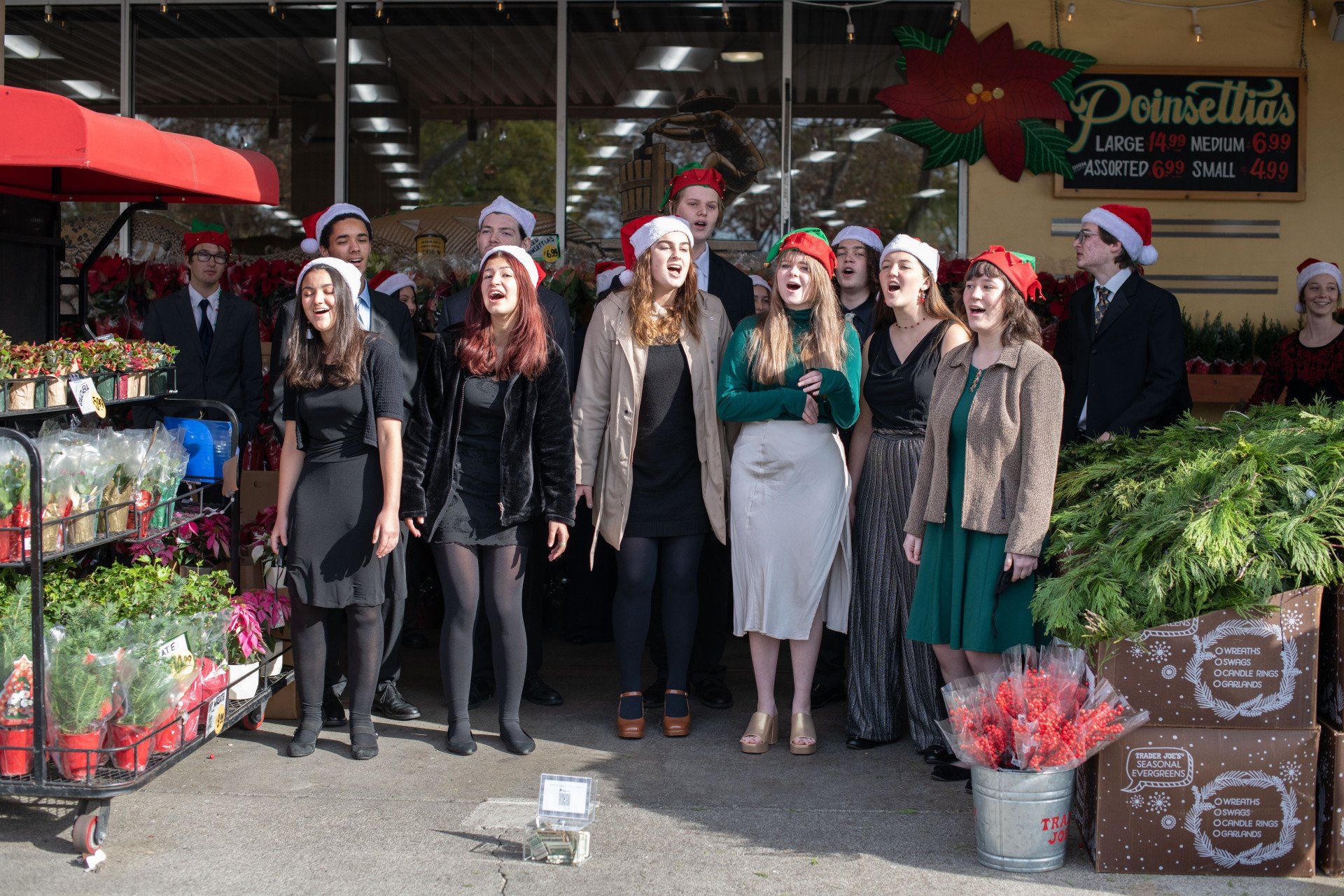 A group of people wearing santa hats are standing in front of a store.