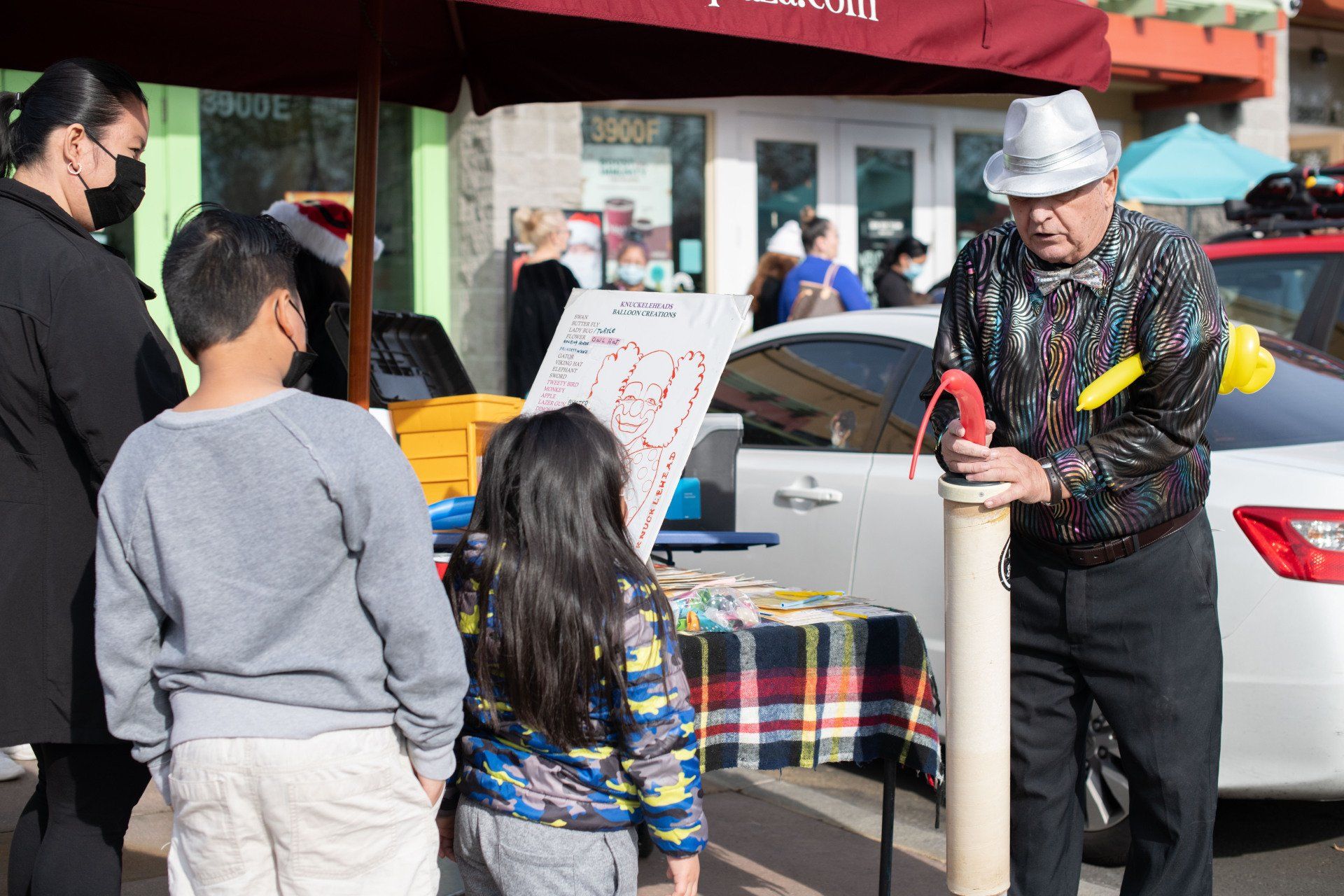 A man is holding a fire extinguisher in front of a group of children.