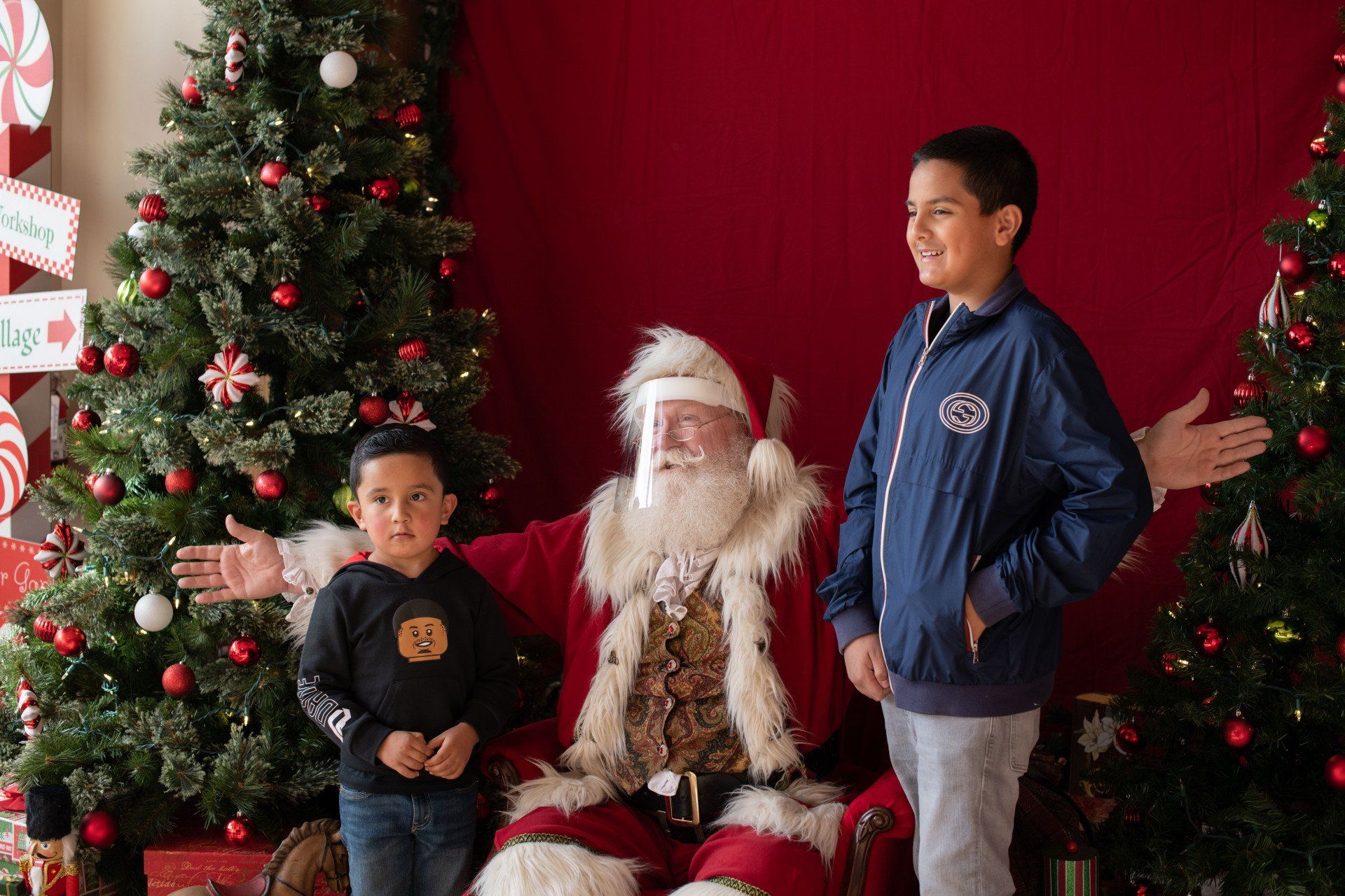Two young boys are posing for a picture with santa claus.