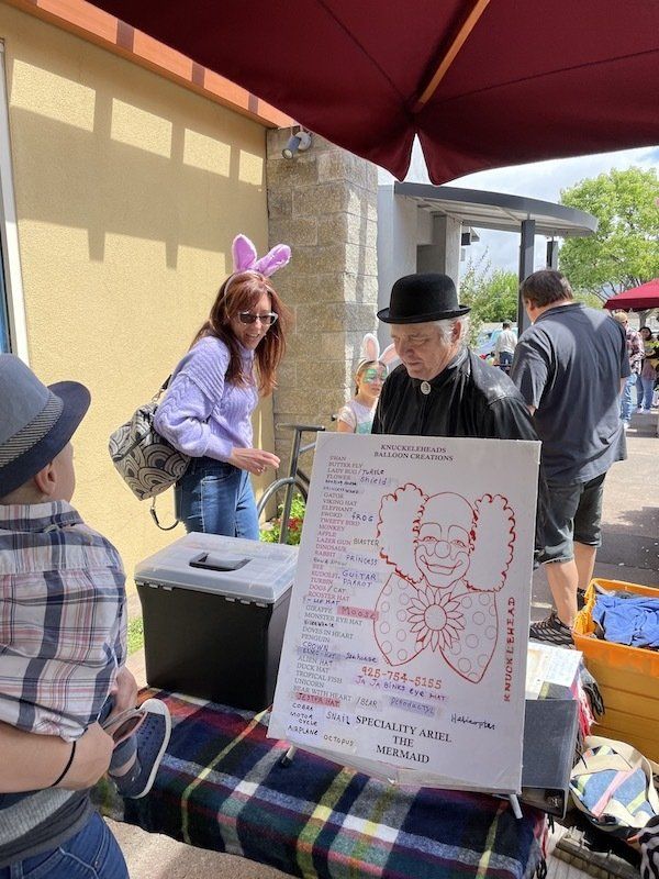 A man in a top hat is standing next to a table with a sign on it.