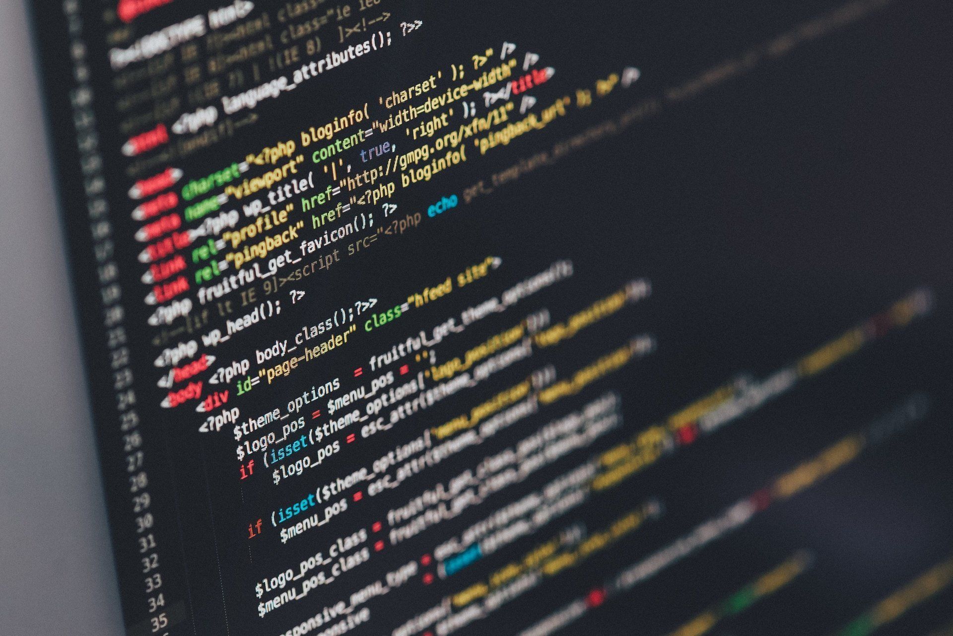 Close-up of colorful code on a dark computer screen, with lines of programming text in focus.