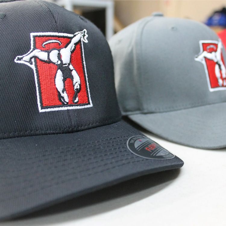 Two baseball caps, black and gray, with red-and-white logo patches on the front.