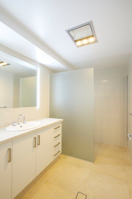 A Bathroom With a Sink a Mirror and a Walk in Shower — Mid Richmond Plumbers & Suppliers in Coraki, NSW