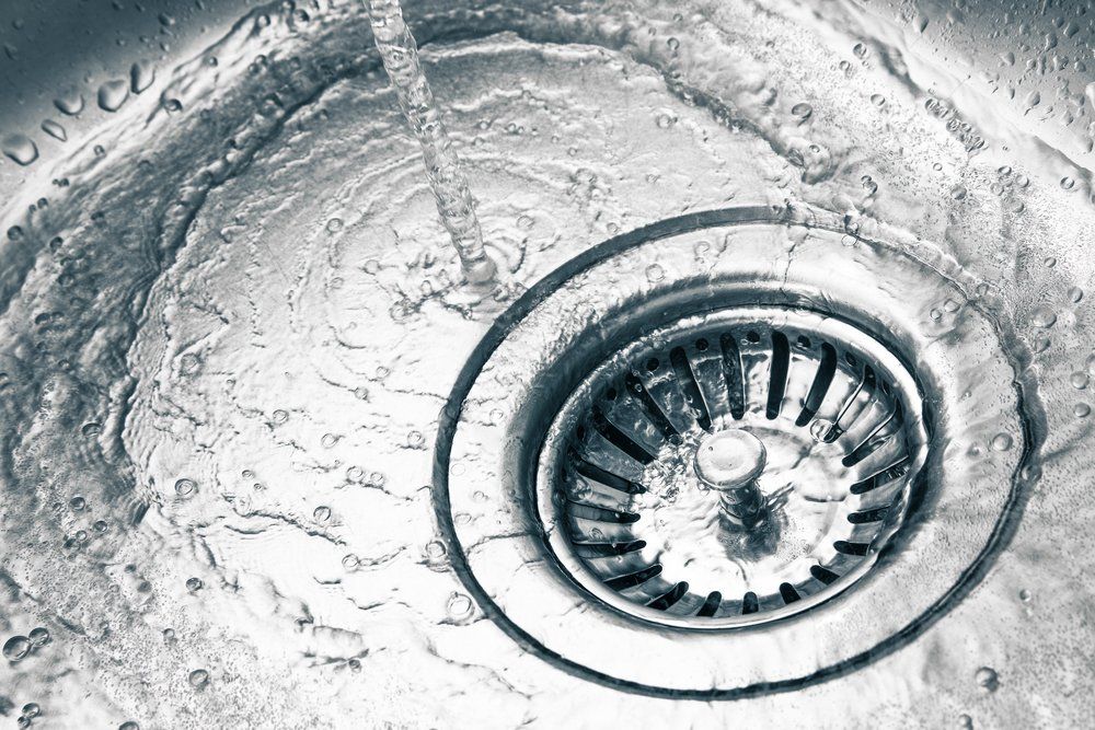 Black and White Photo of a Sink Drain With Water Coming Out of if — Mid Richmond Plumbers & Suppliers in Casino, NSW