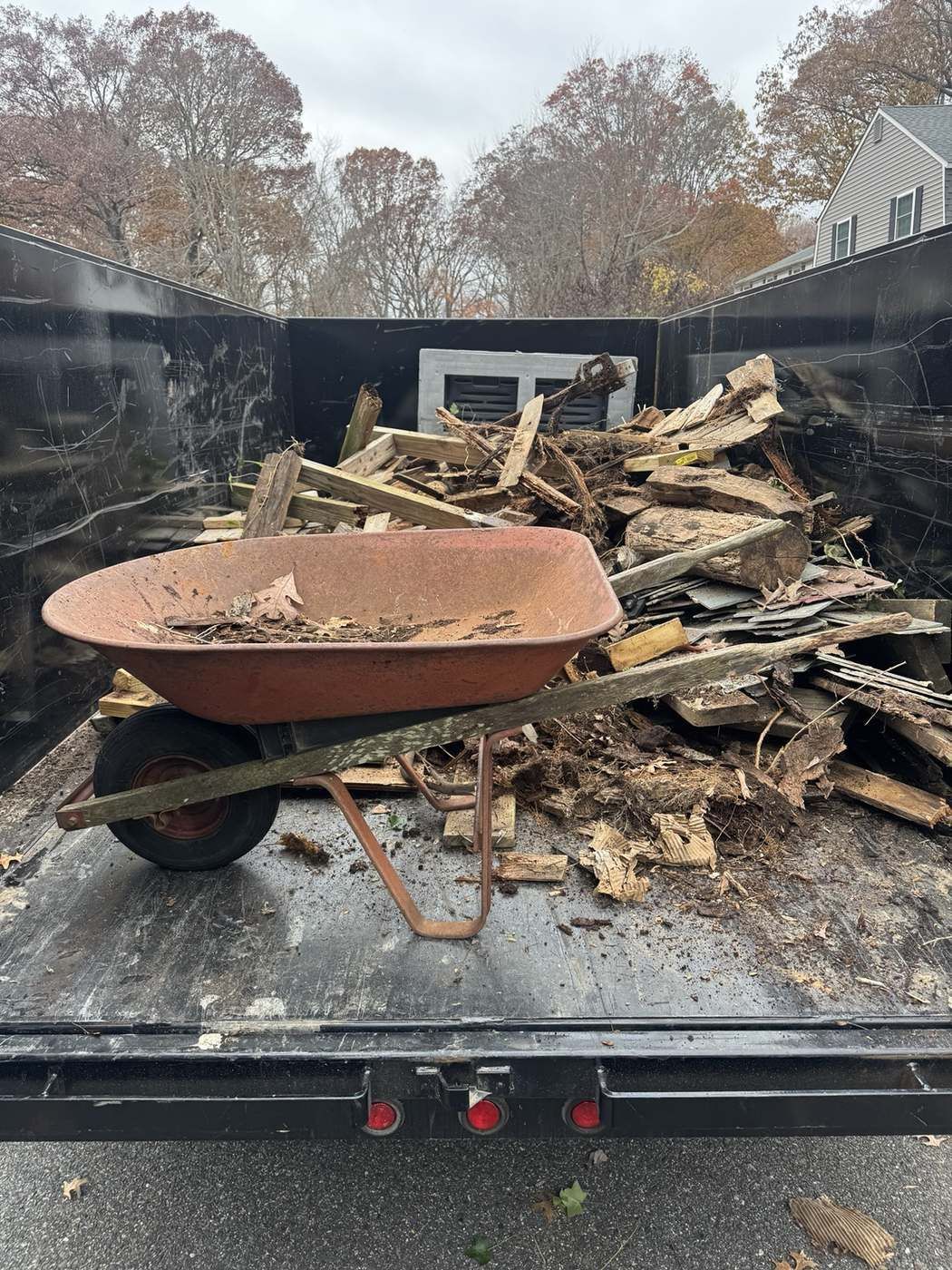Wheelbarrow and wood scraps loaded in trailer for haul away