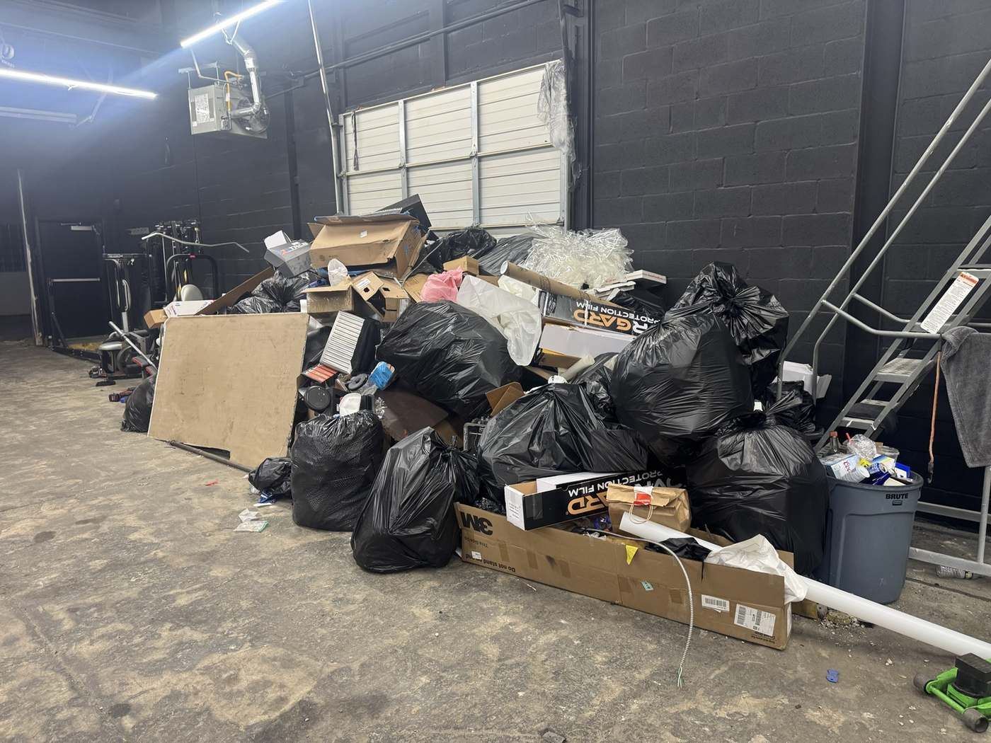 Warehouse floor piled with bagged junk, boxes and debris ready for haul away