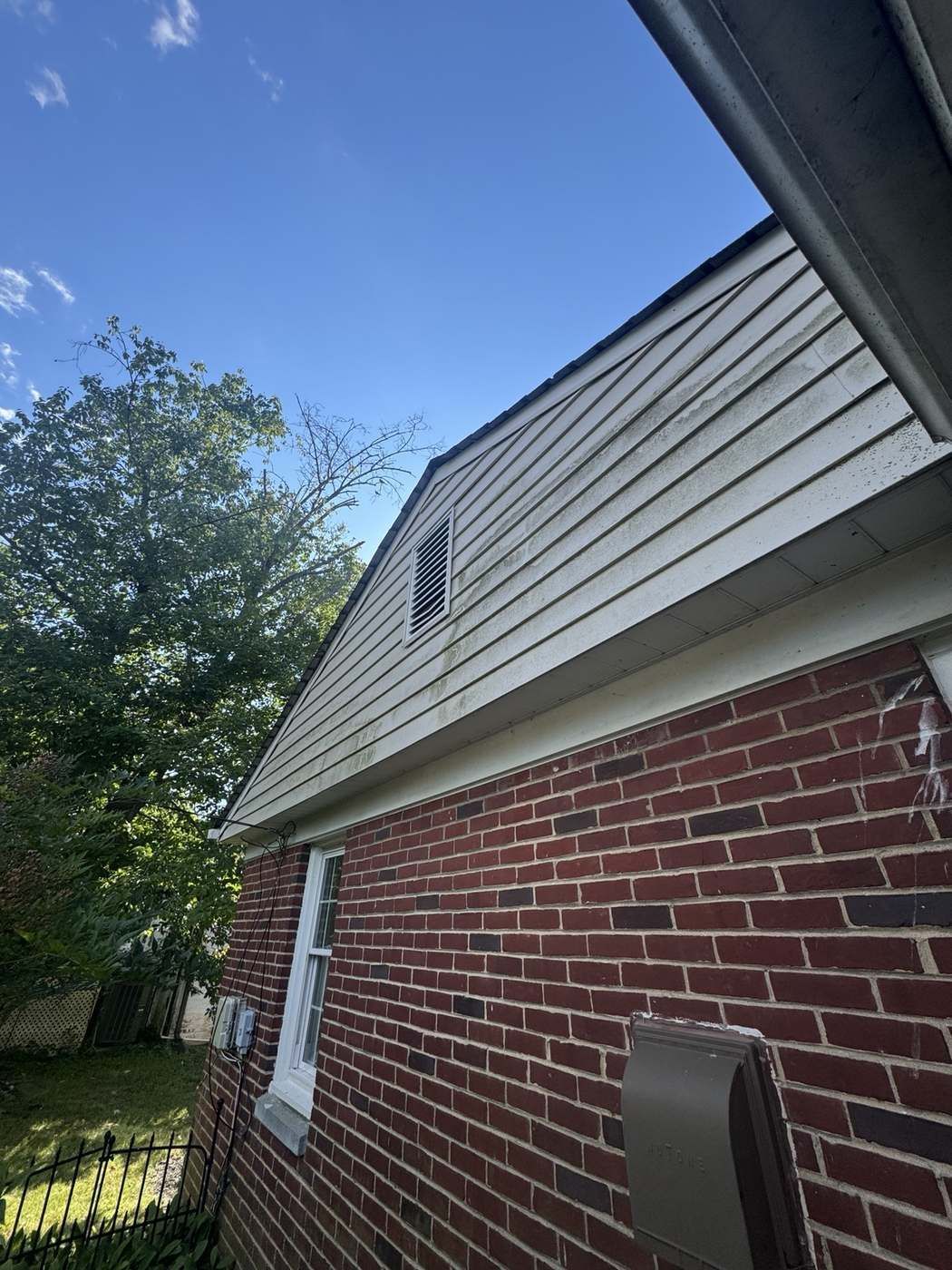 House siding and gable with mold and staining before soft washing