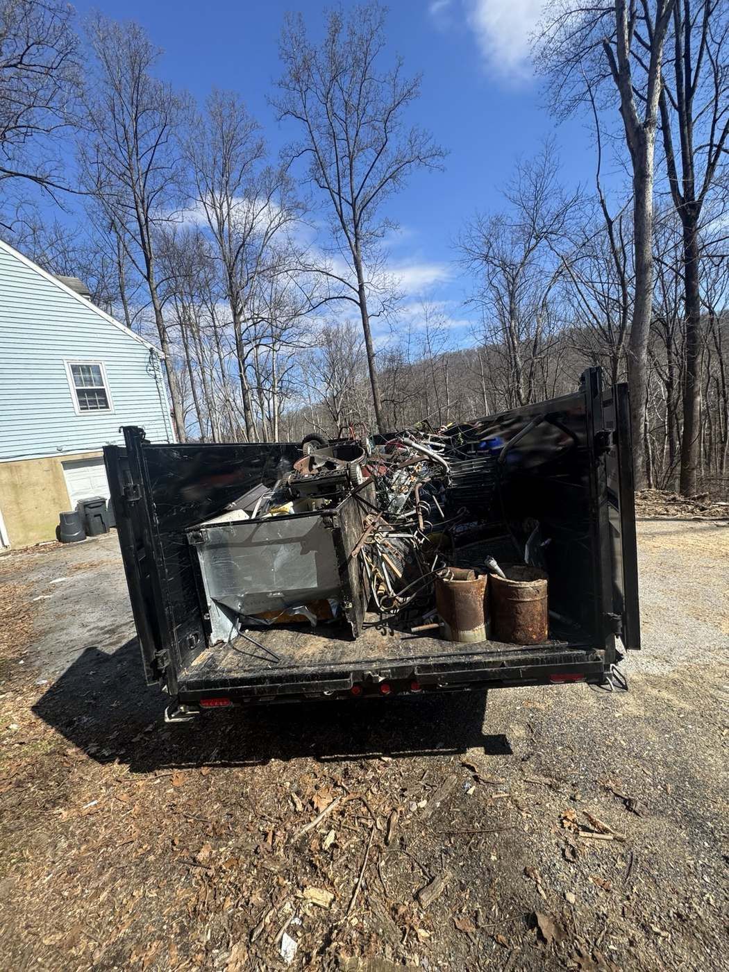 Dump trailer loaded with scrap metal and old appliances