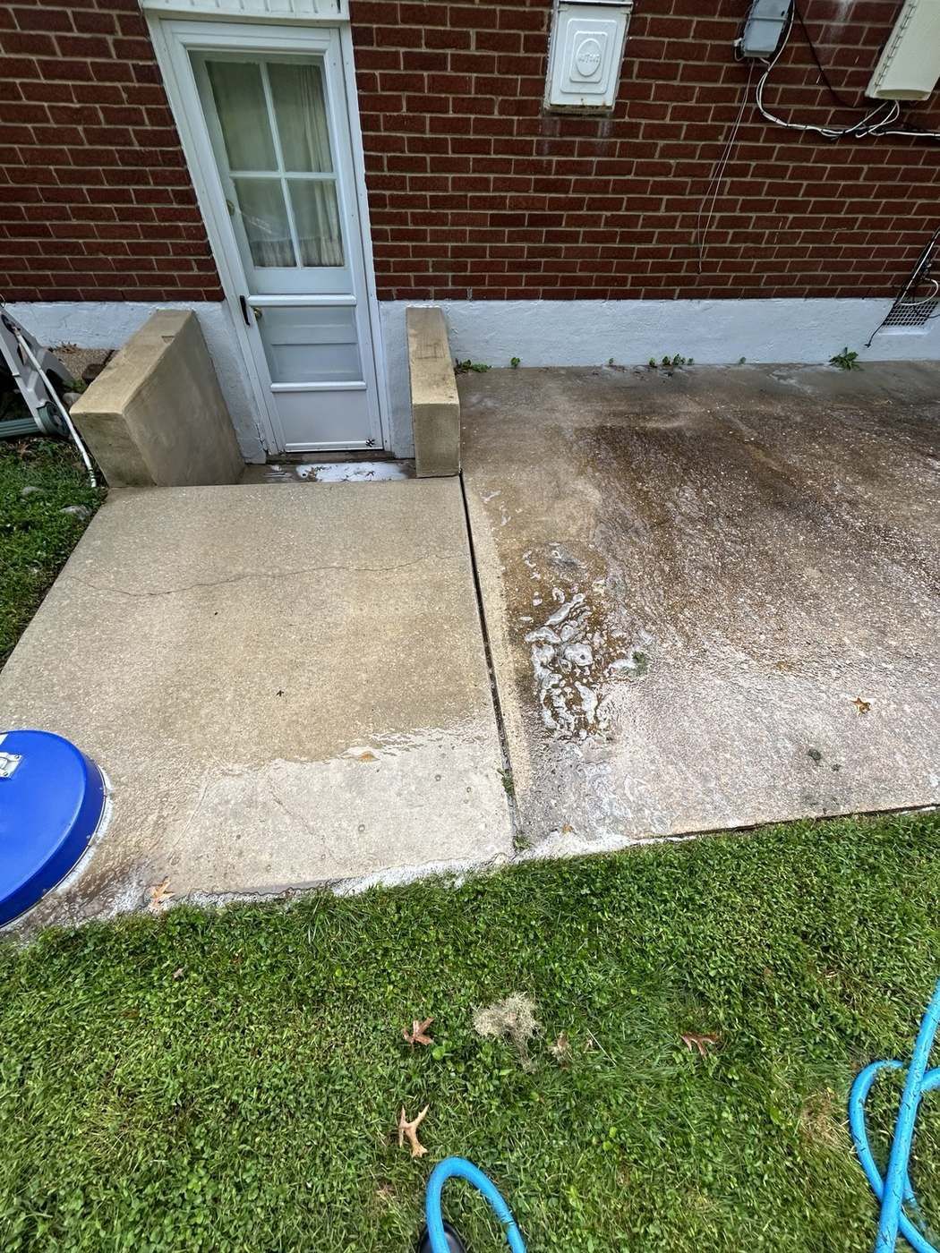 Side patio and steps partway through pressure washing with foam solution