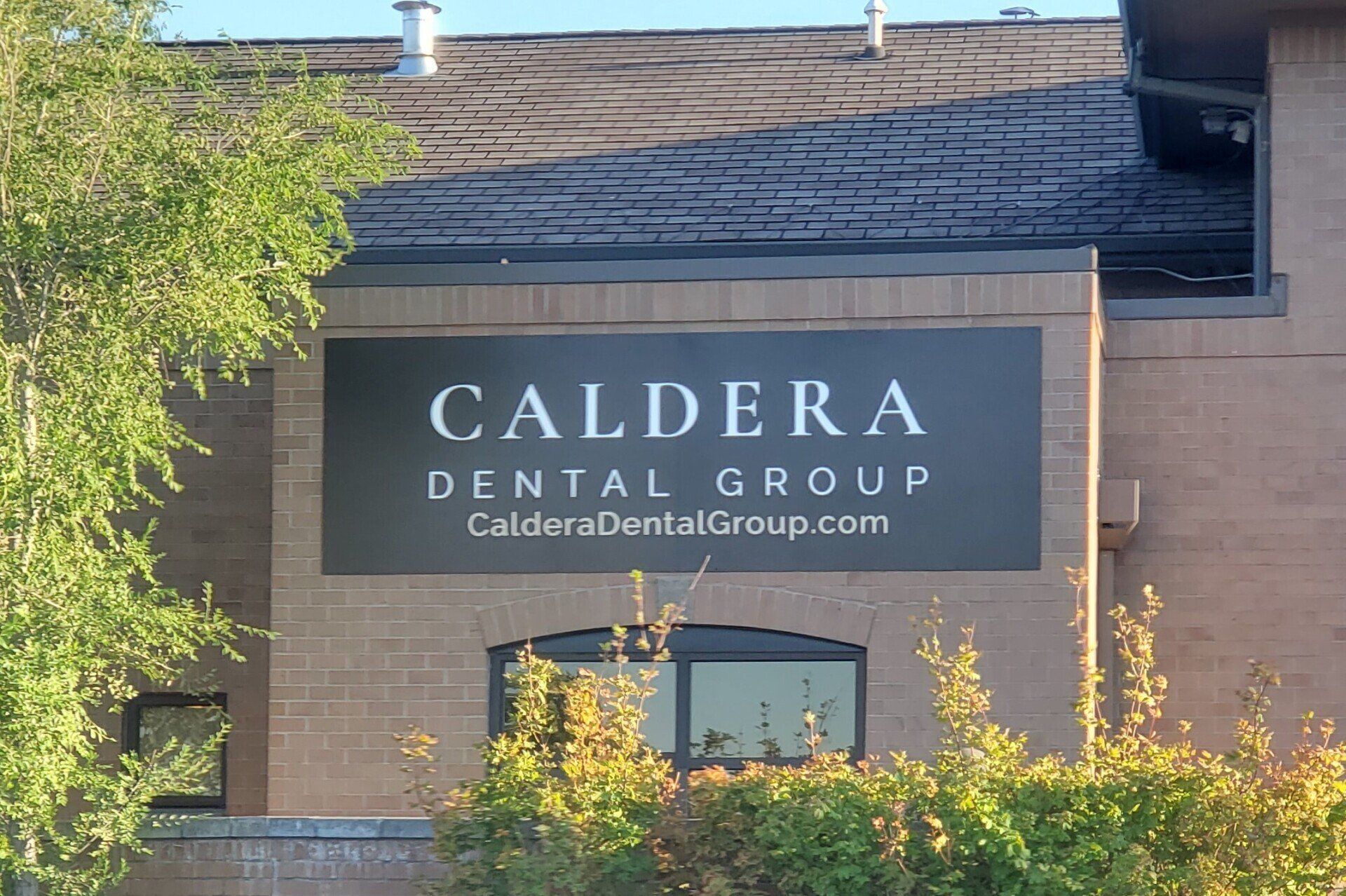 A building with a sign that says caldera dental group