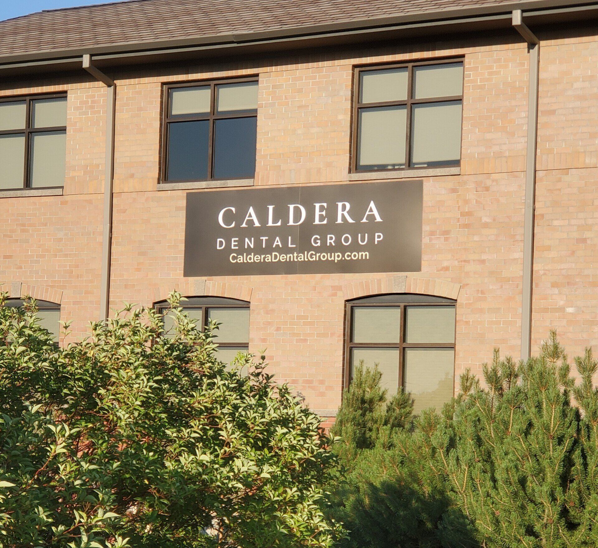A brick building with a sign that says caldera dental group