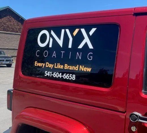 A red jeep with onyx coating written on the back window