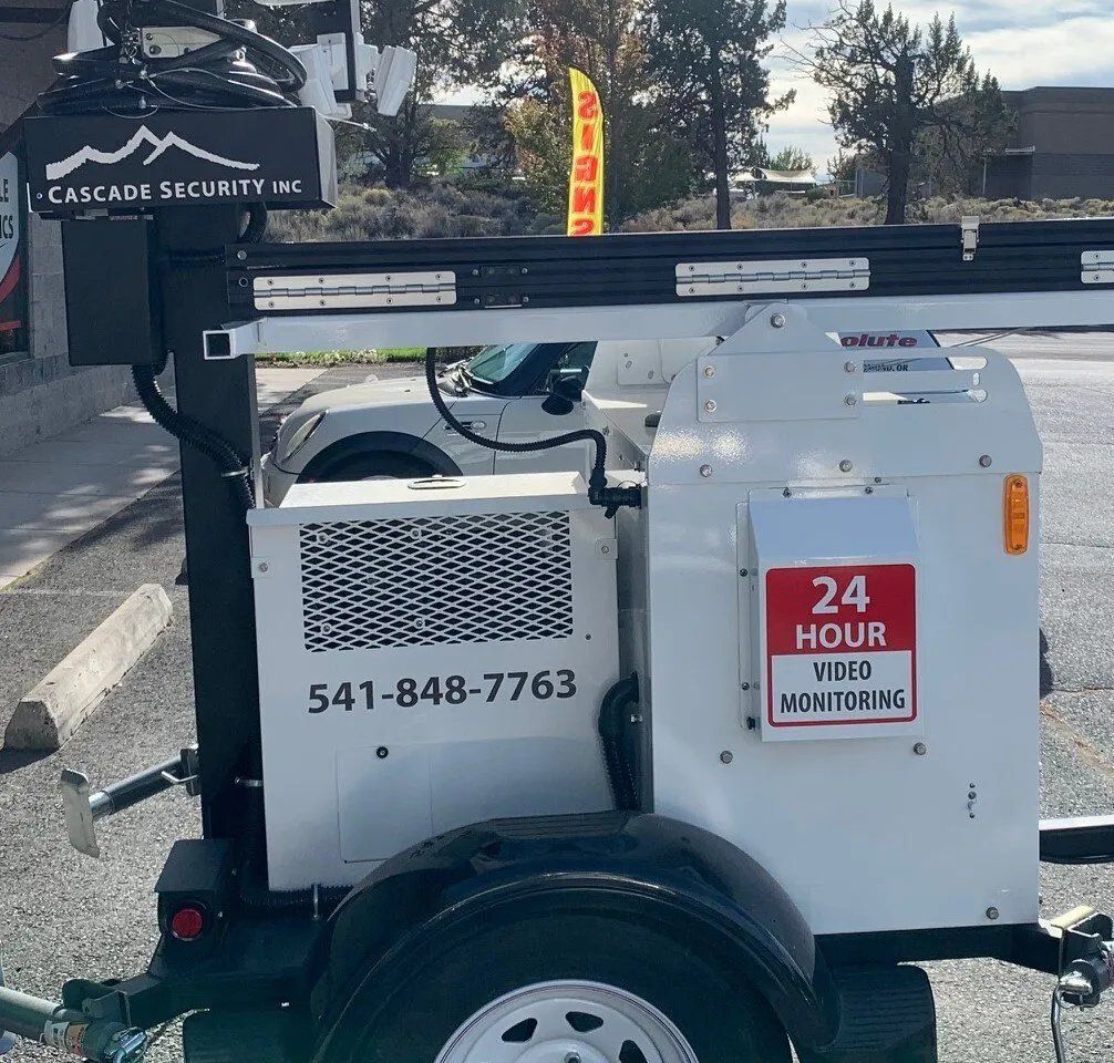 A white vehicle with a 24 hour video monitoring sign on it