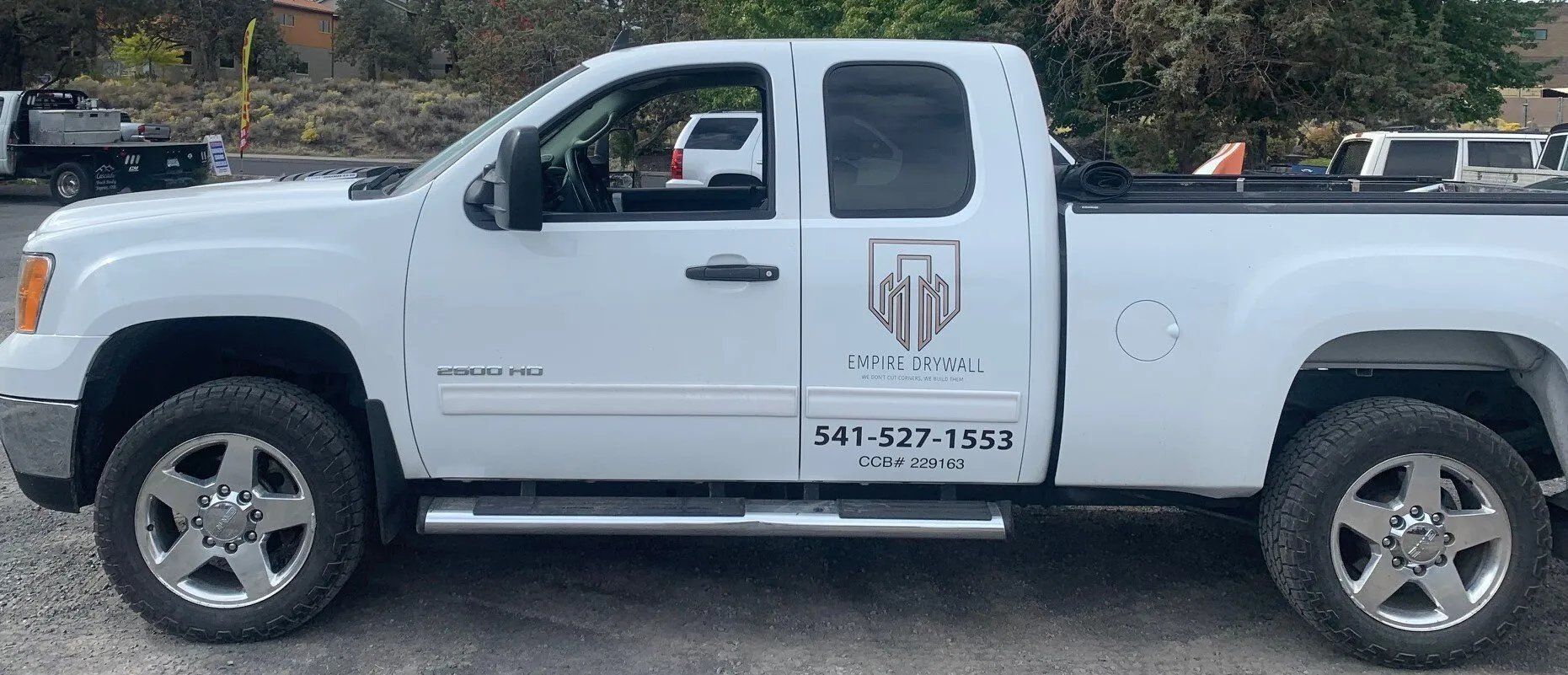A white truck is parked on the side of the road.