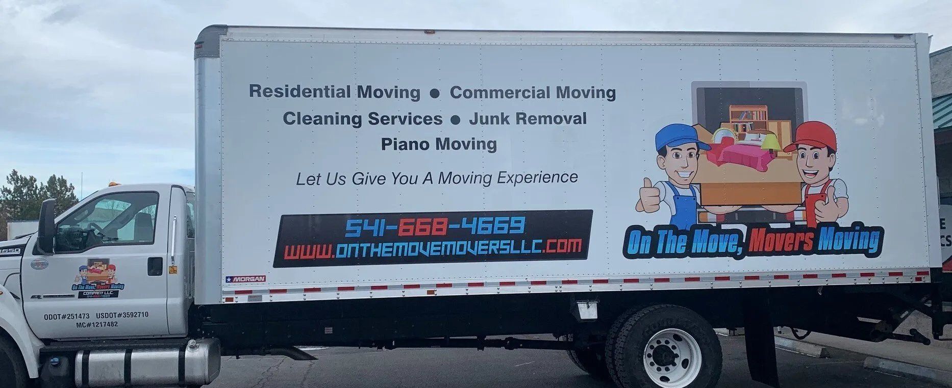 A white moving truck is parked in a parking lot.