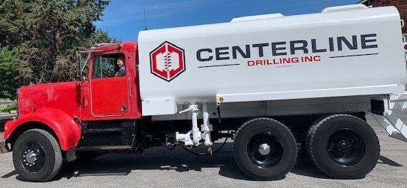 A red and white centerline drilling truck is parked in a parking lot.