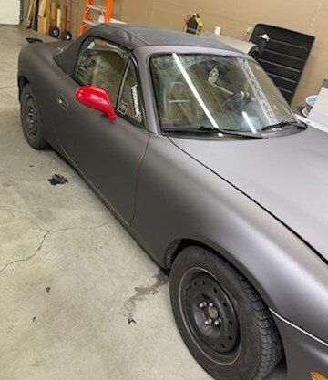 A black sports car is parked in a garage.