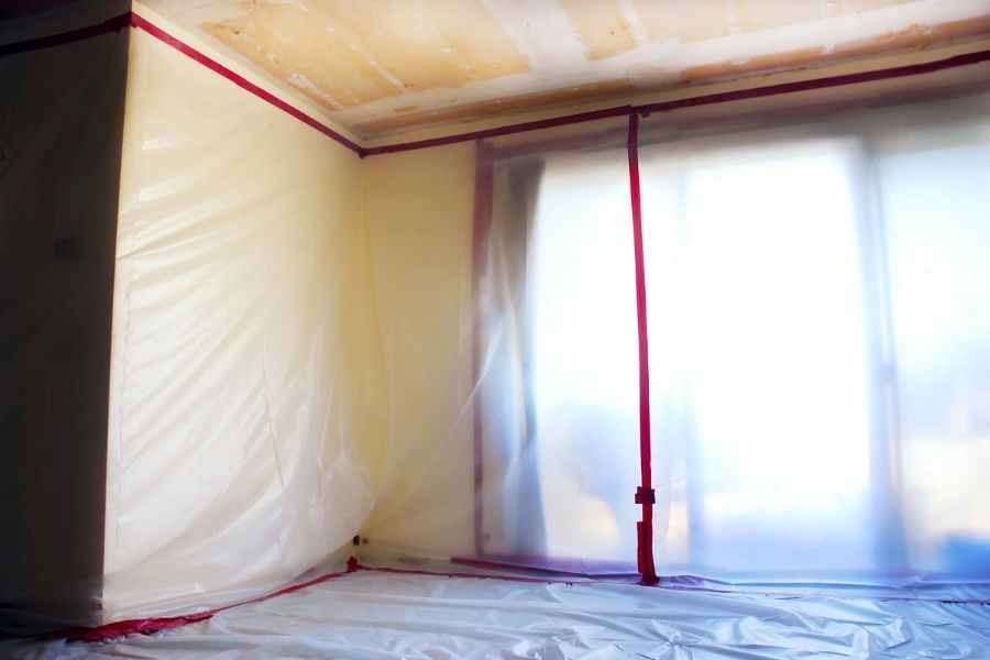 Professional restoration crew setting up containment barriers to prevent mold and bacteria from spreading to unaffected rooms