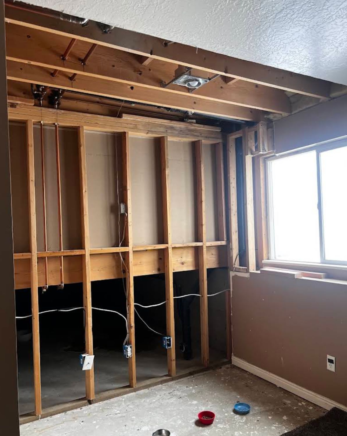 Open wall and ceiling cavity showing exposed framing and insulation removal during water damage restoration in Layton UT