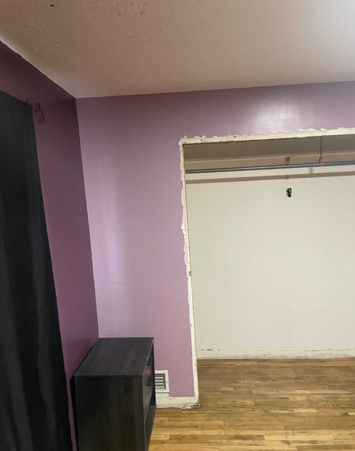 Bedroom with purple walls and open closet without doors during renovation in Kaysville home