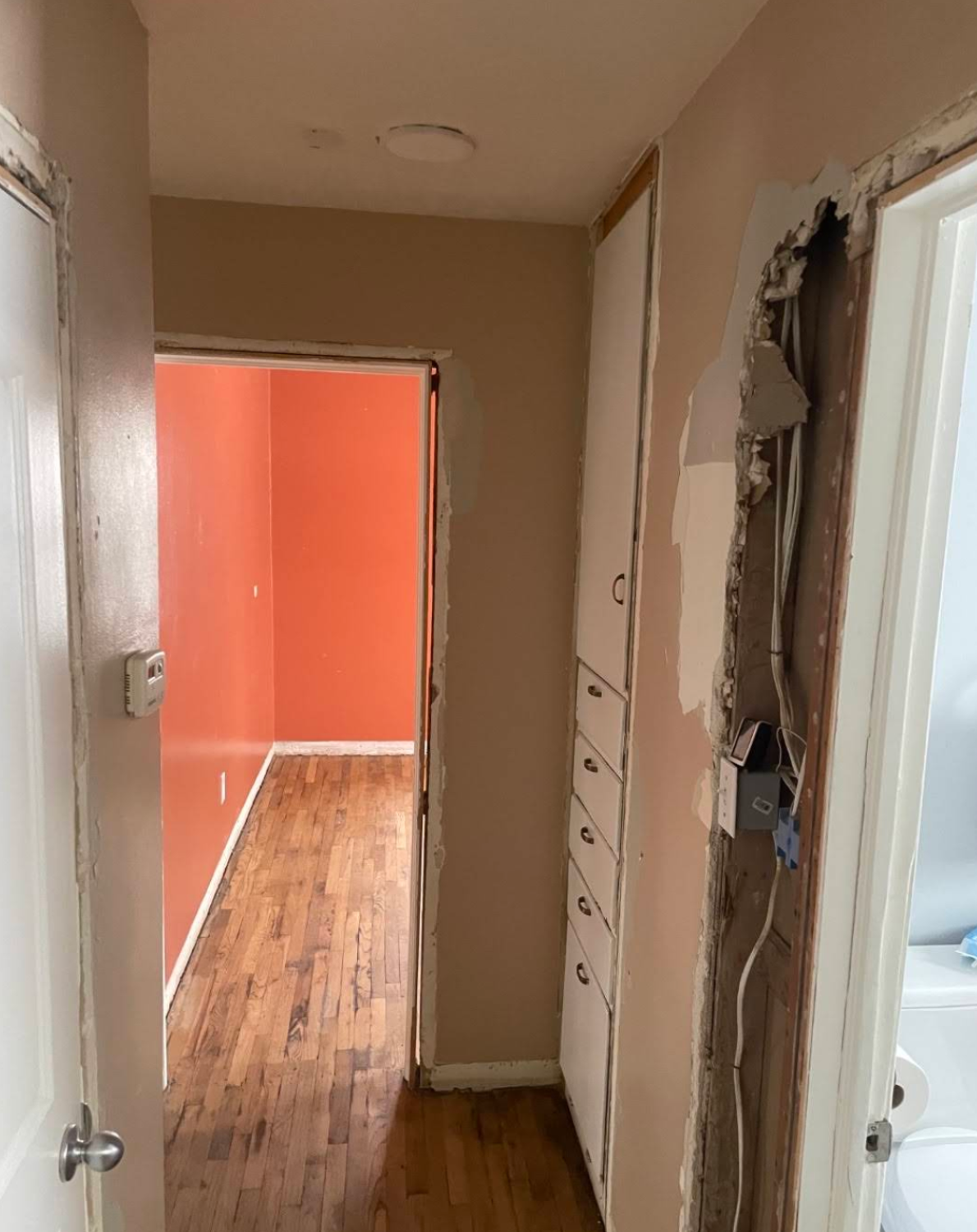Hallway showing exposed wiring and old storage drawers during whole-home remodel