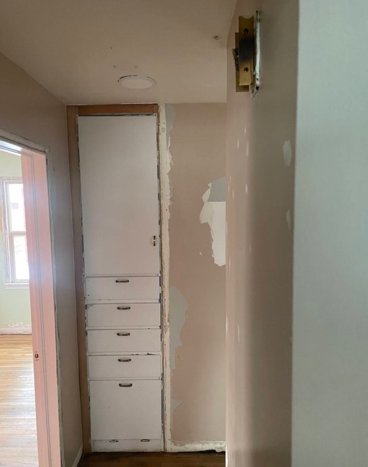 Hallway during renovation showing drywall work and exposed wall framing