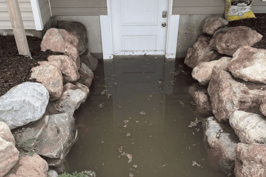 Floodwater pooling at a basement entry point during a water damage emergency