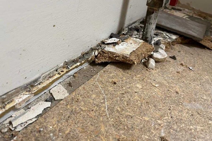 Damaged flooring and baseboards being removed during a water damage restoration project