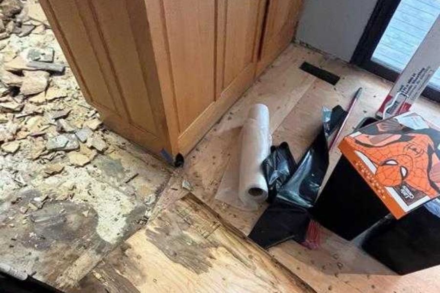 Flooring removal during a restoration project, exposing subfloor and releasing dust and particles that affect indoor air quality