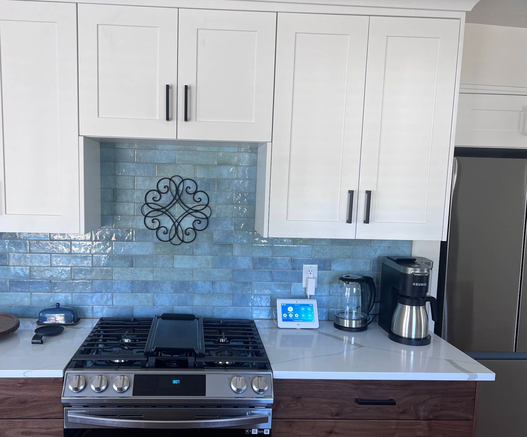 Open-concept kitchen and living room with walnut lower cabinets and refinished hardwood floors