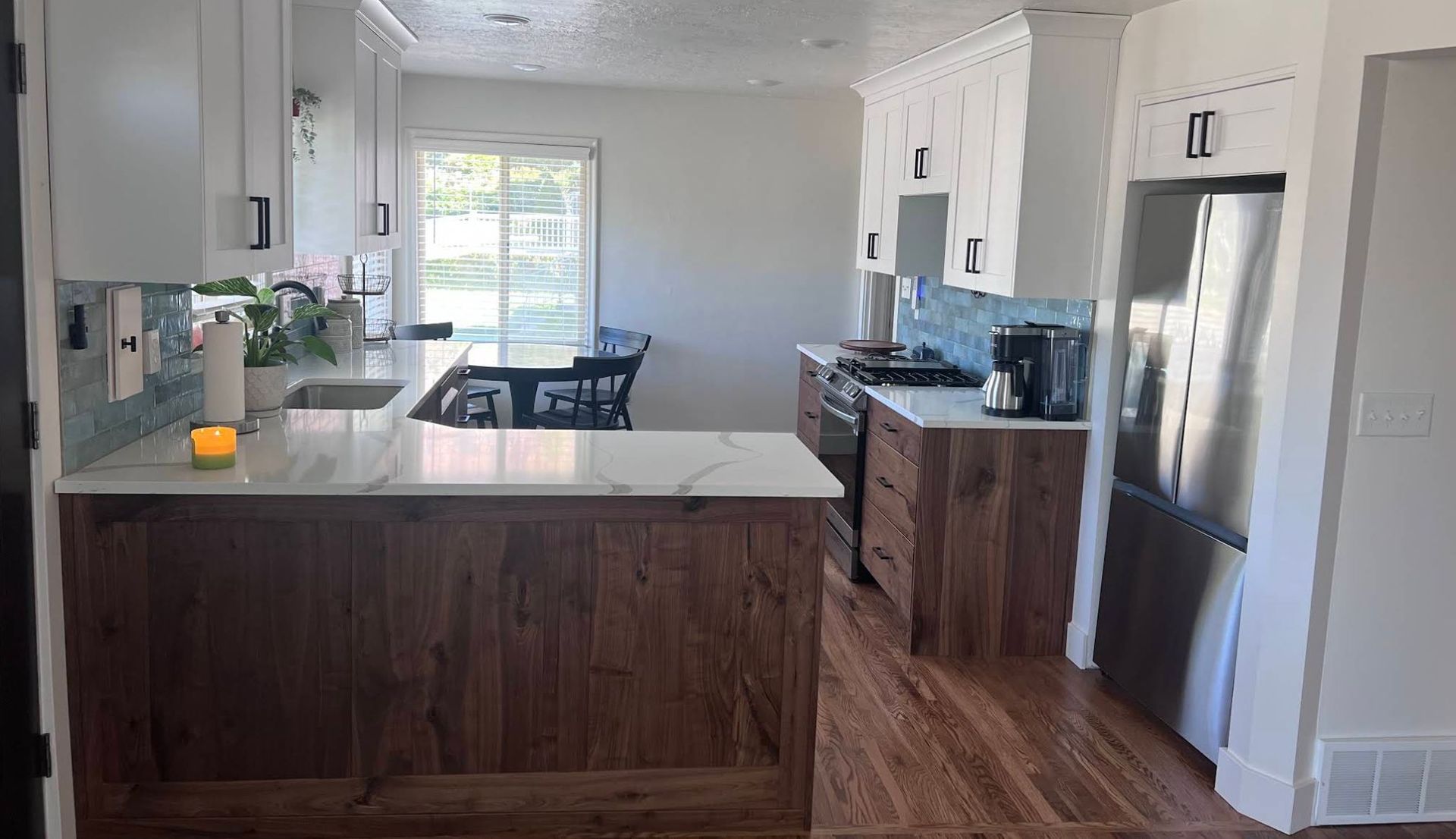 New gas range with white shaker cabinets and blue subway tile backsplash after kitchen remodel